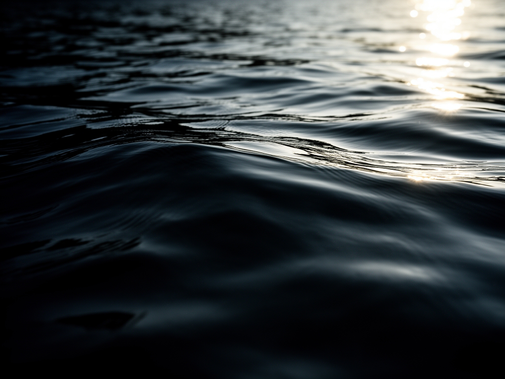 Kvinematografisk närbild av vatten med djupa skuggor och riktat ljus som skapar en känsla av lugn och djup